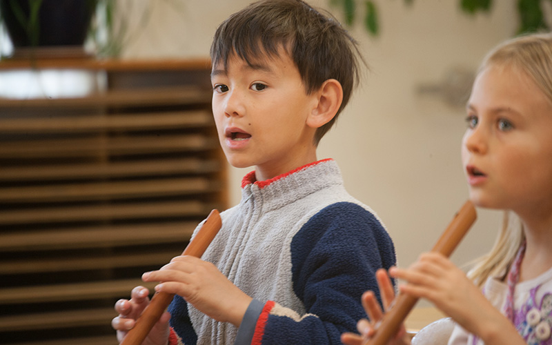 two elementary students learning to play wooden flutes at Waldorf School of the Peninsula