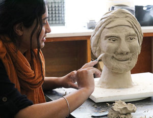 11th grader girl sculpting a clay bust