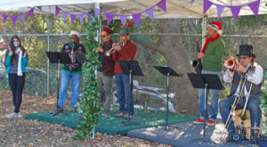 Photo of alumni and parents with musical instruments on a festive stage.